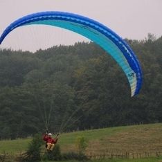 Paragleitsprung auf unserem eigenen Trainingsgelände mit Wiese und Bäumen im Hintergrund