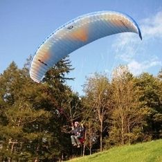 Paragleitsprung auf unserem eigenen Trainingsgelände mit Bäumen im Hintergrund