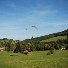 Paragleitsprung auf unserem eigenen Trainingsgelände mit Hügel im Hintergrund