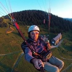 Ein Selfie eines Paragleiters im Flug über den Bergen