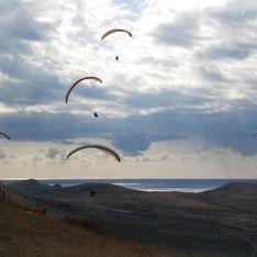 Mehrere Paragleiter beim Fliegen über den Bergen