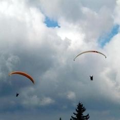 Zwei Doppelsitzer beim Fliegen vor wolkigem Himmel im Hintergrund
