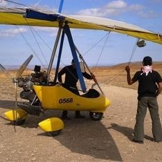 Ein motorisierter Gleiter in Nahaufnahme auf einer Wiese mit zwei Personen