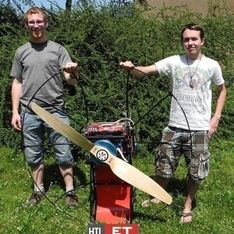 Ein Motor in Nahaufnahm mit zwei Männern im Hintergrund