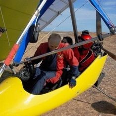 Ein motorisierter Gleiter in Nahaufnahme auf einer Wiese mit zwei Personen