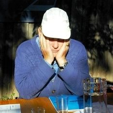 Ein Mann stützt sich auf seinen Händen ab auf einem Tisch